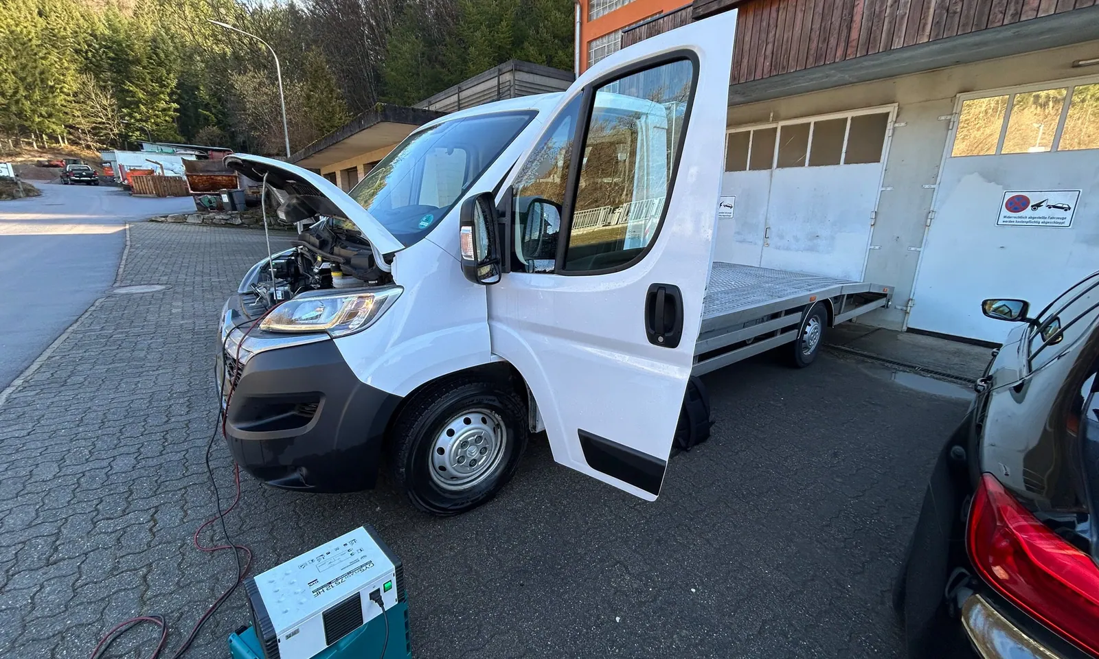 Fiat Ducato mit geöffneter Motorhaube vor der Werkstatt