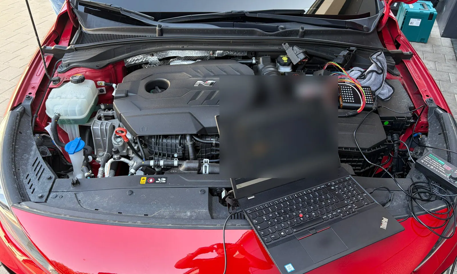 Hyundai i30 N mit geöffneter Motorhaube und Diagnoselaptop