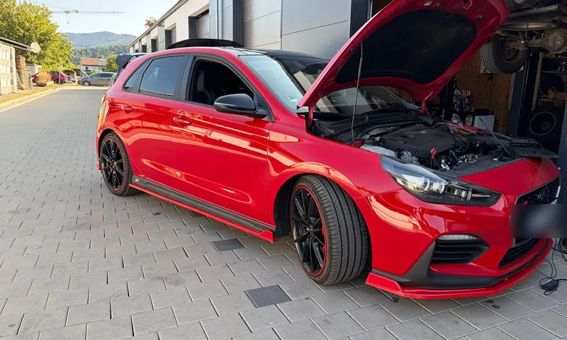 Hyundai i30 N mit geöffneter Motorhaube vor der Werkstatt