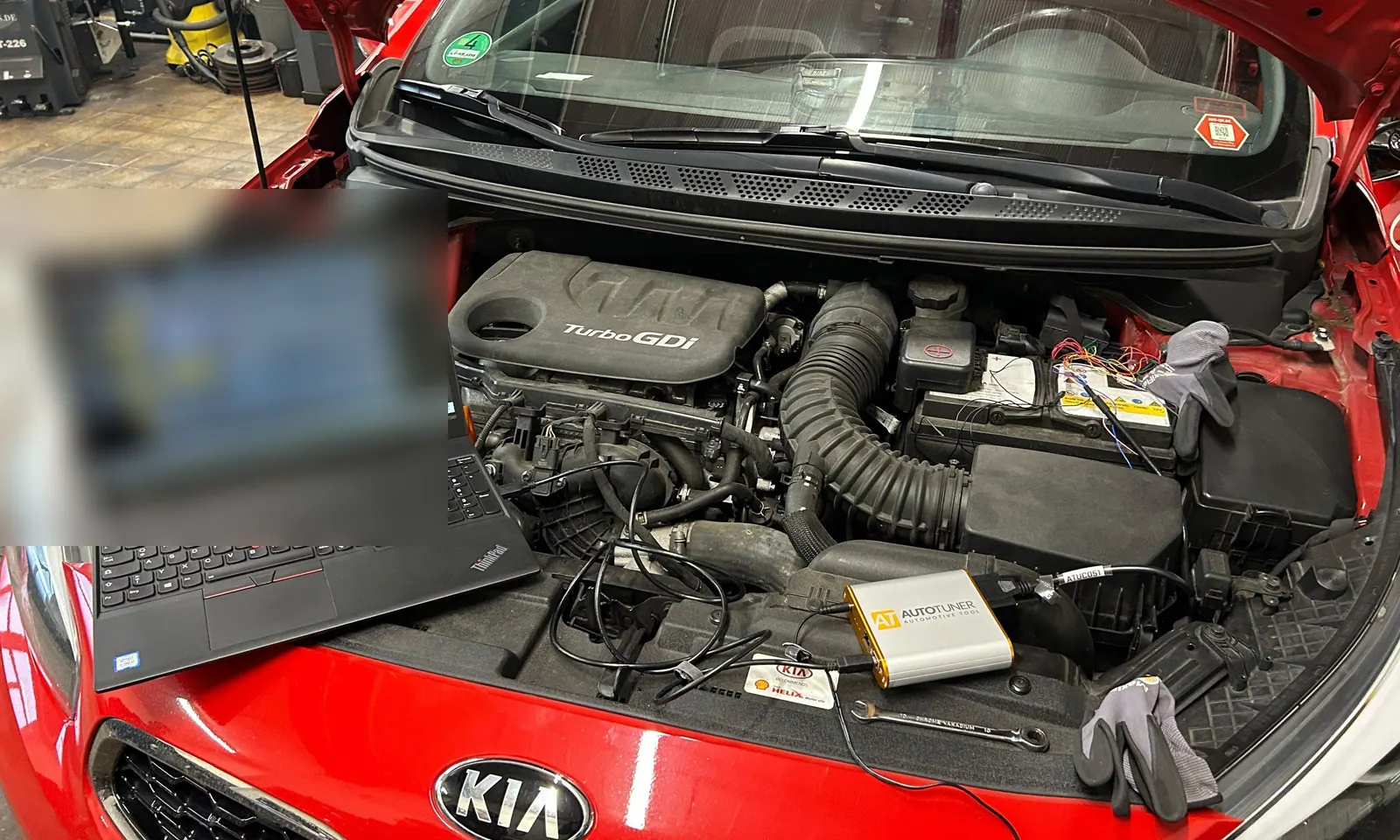 Kia mit Turbo-GDI-Motor und Diagnoselaptop auf dem Motorraum