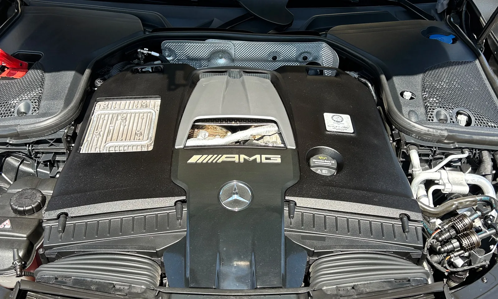 Motorraum eines Mercedes-AMG mit V8-Abdeckung und Mercedes-Stern